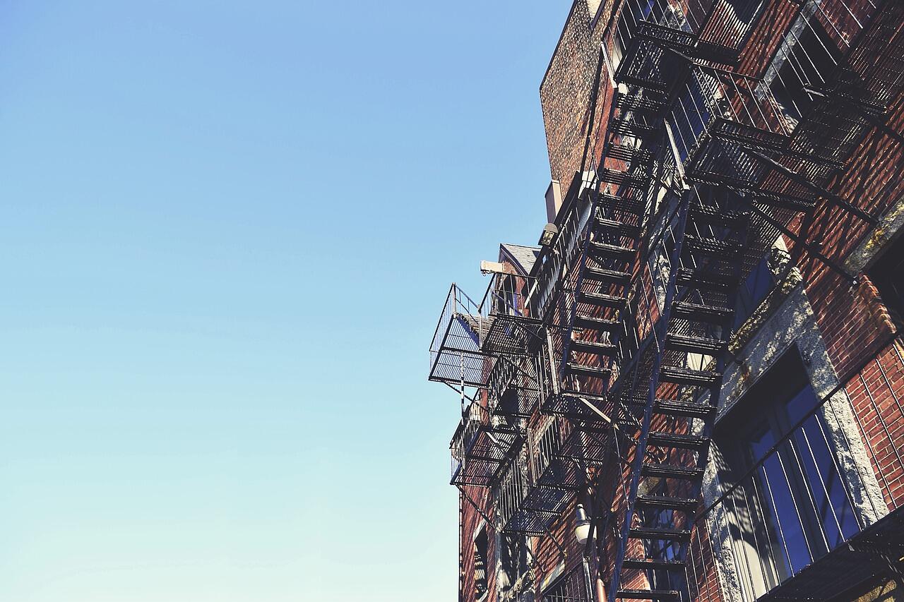 The facade of a high-rise building with access scaffolding against the sky